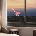 high floor inside of Hotel Fera Anaheim, a DoubleTree by Hilton seeing fireworks through window