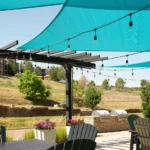 An outdoor patio with string lights and a shade sail at a Broomfield, CO hotel