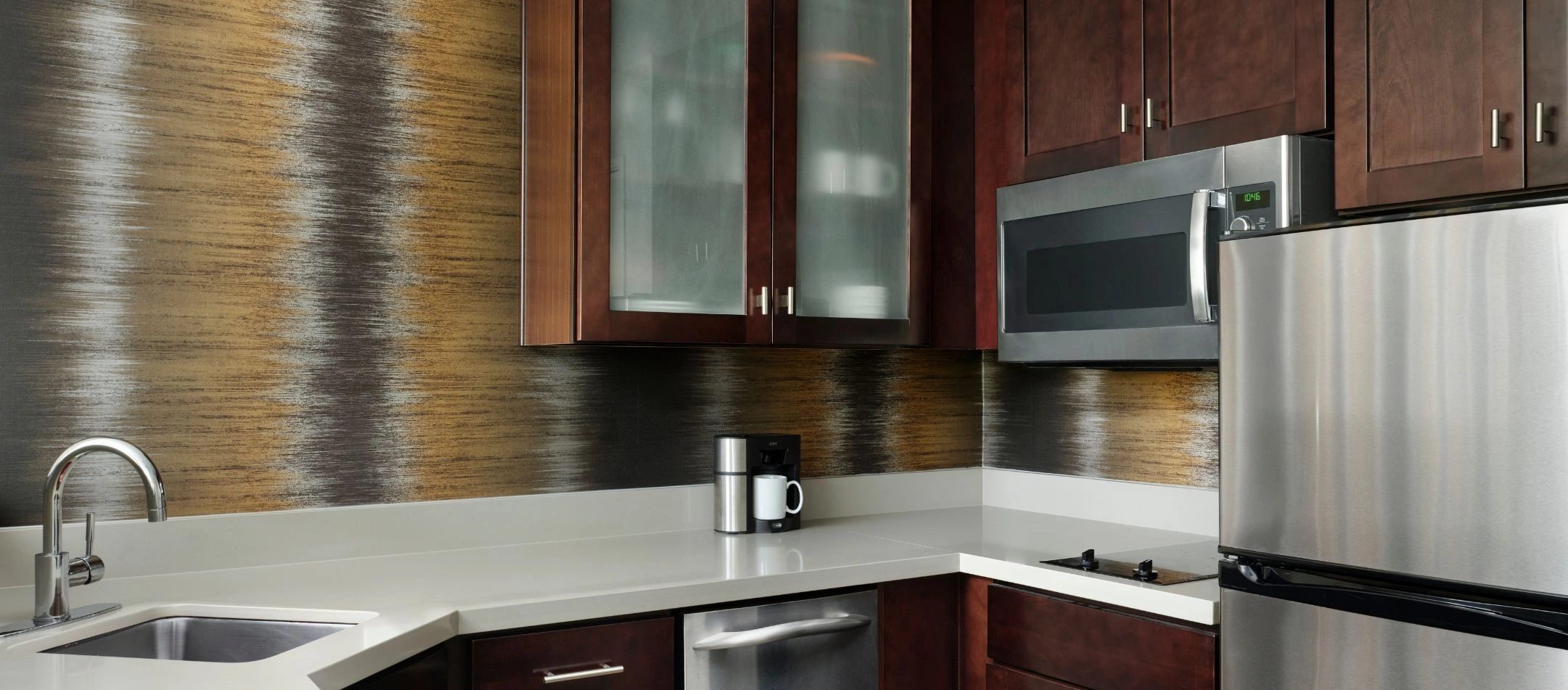 A kitchenette with a stainless steel fridge at a Broomfield, CO hotel