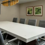 A boardroom with a marble table and gray leather chairs at a Broomfield, CO hotel