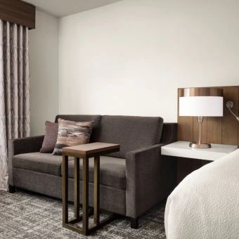 the couch area in a guest room at hilton detroit downtown