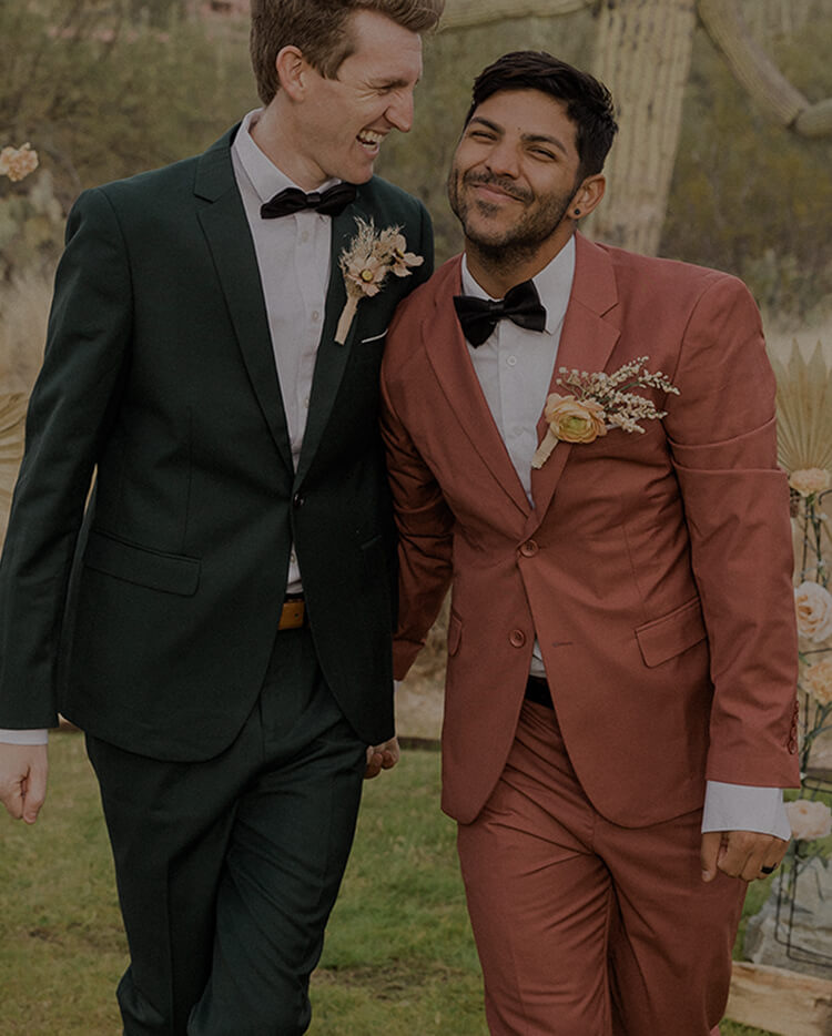grooms smile while walking on their wedding day