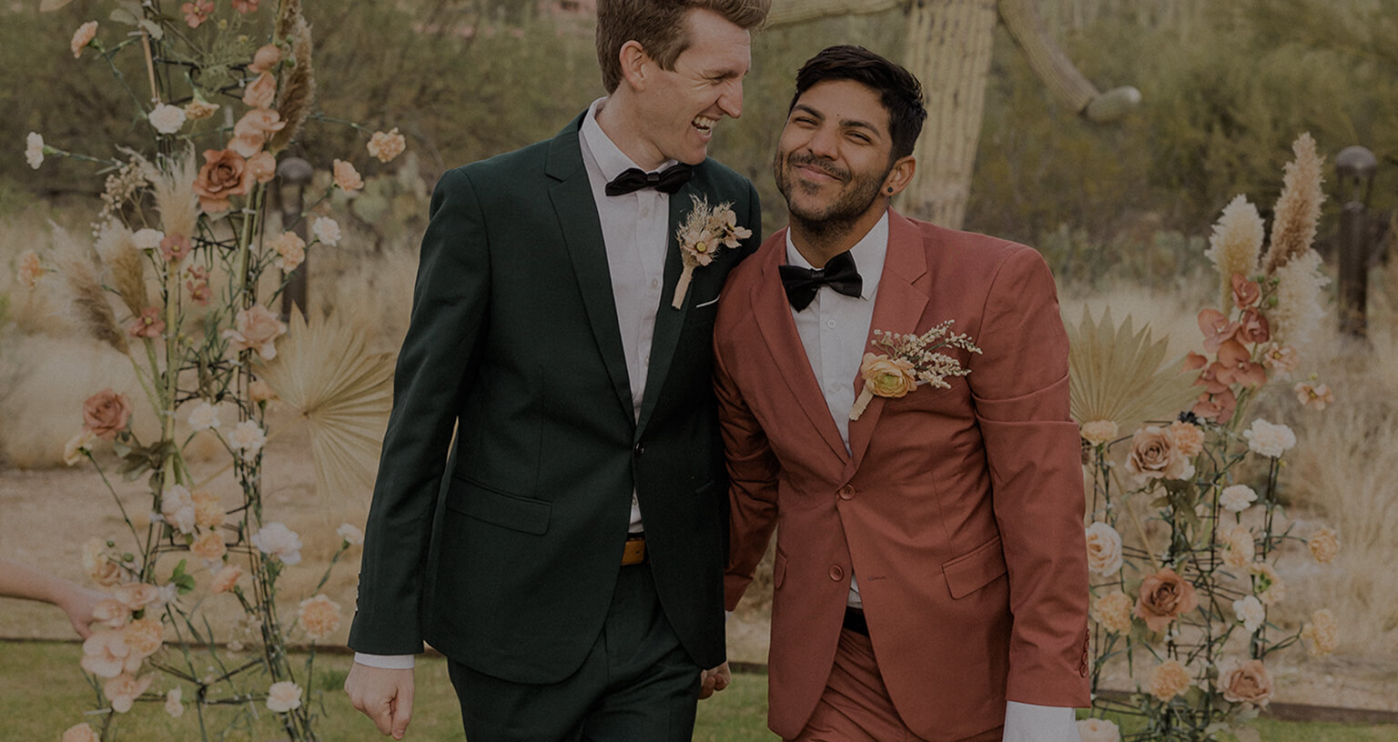 grooms smile while walking on their wedding day