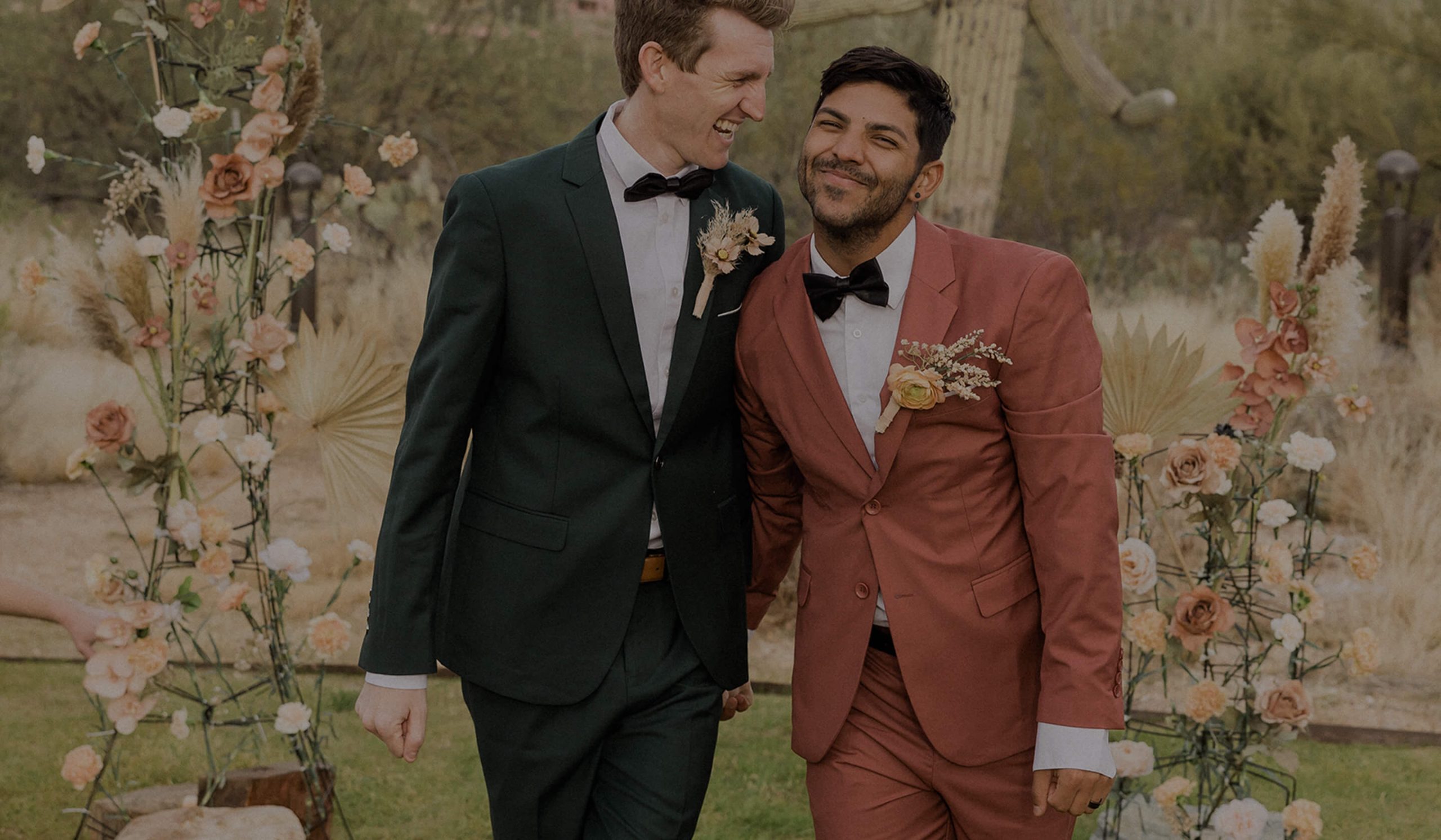 grooms smile while walking on their wedding day