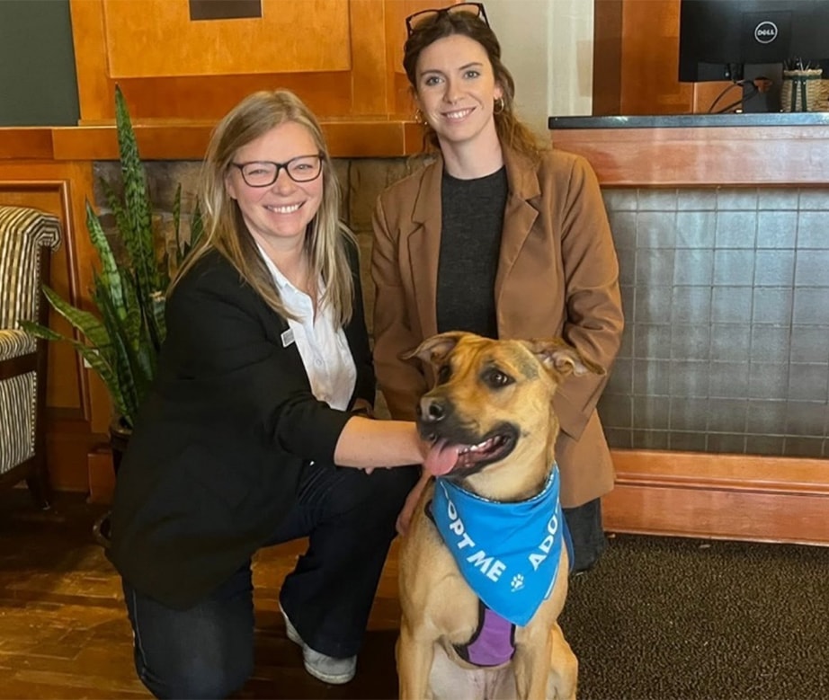 two woman smiling with dog
