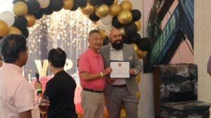 Two men posing for a picture with certificate